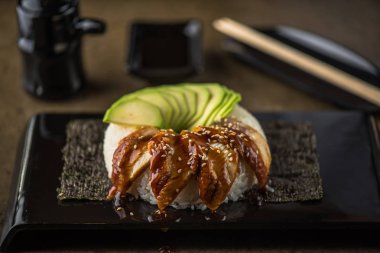 Yılan balığı ve kara tahta üzerinde avokado ile Japon Suşi