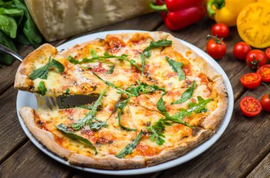 parmesan peyniri, roka ve domates ile güzel pişmiş pizza ahşap masa üzerinde görmek