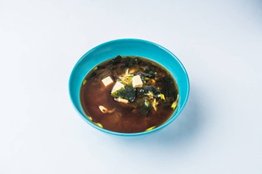 Geleneksel Japon miso çorbası beyaz zemin üzerine mavi kapta bölümünü