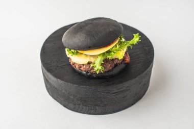 Parça ahşap beyaz arka plan üzerinde siyah sığır eti burger hizmet