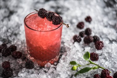 Kokteyl cam buz ile koyu arka plan üzerinde böğürtlen ile dekore edilmiş