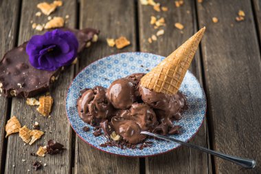 Çikolatalı dondurma topları desen ahşap masa üzerinde gözleme koni ile tabakta