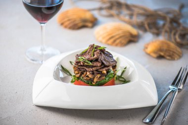 Beyaz tabakta et ve sebze yemek