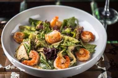 Tabak koyu arka plan üzerinde ızgara karides ile sebze salatası