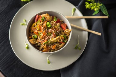 Siyah kumaş üzerine yemek çubukları ile plaka üzerinde Asya kase erişte