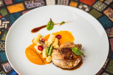 Renkli mozaik zemin üzerine beyaz tabakta ördek bacak garnitür ile servis