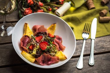 İştah açıcı jambon, çilek ile lahanası kase beyaz şarap ile ahşap tablo