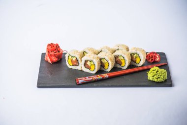 yakından görmek lezzetli Japon suşi rulo ton balığı, wasabi, zencefil ve yemek çubukları ile gri arka plan üzerinde kayrak gemide