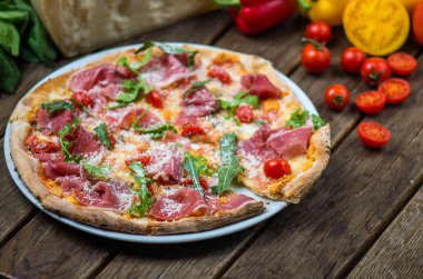 et, roka, parmesan ve kiraz domates ile güzel pişmiş pizza ahşap masa üzerinde görmek