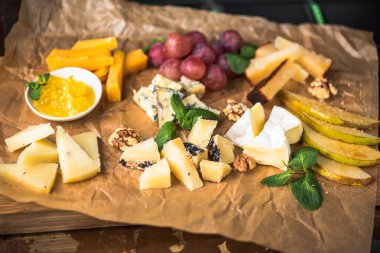 Parşömen üzerine peynir ve meyve meze eşliğinde