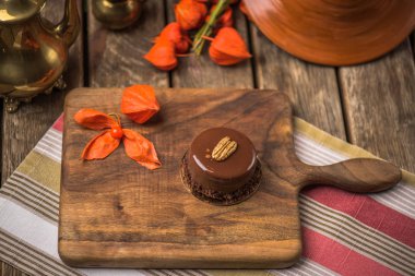 Yaprakları ile ahşap tahta üzerinde tatlı çikolata pasta servis