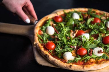 dilim taze domatesli pizza alarak el roka ve mozzarella peyniri