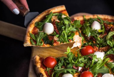 dilim taze domatesli pizza alarak el roka ve mozzarella peyniri