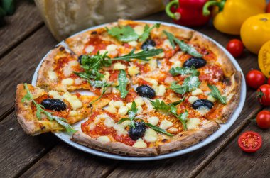 Roka ve ahşap masa tabakta servis zeytin İtalyan pizza