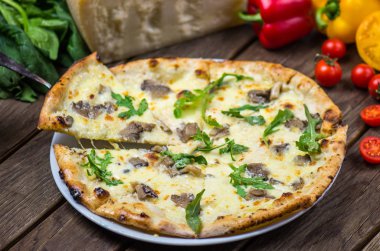 gurme pizza parmesan peyniri, mantar ve roka ahşap masa üzerinde görmek