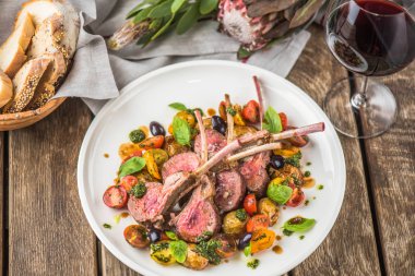 Eti fileto malzemelerle ahşap masa üzerinde plaka üzerinde soslu sebzeli kemikleri üzerinde