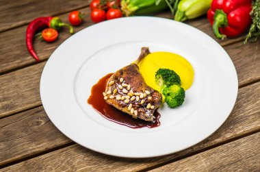 Taze sebze ile ahşap masa üzerinde beyaz tabakta ördek bacak sos ve sebze püresi ile servis