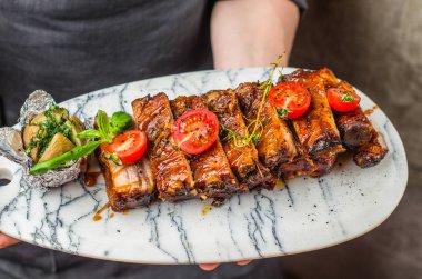soslu kızarmış domuz kaburgaile plaka tutan şef yakın çekim