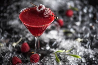 Martini cam buz ile koyu arka plan üzerinde dondurulmuş ahududu ile kokteyl