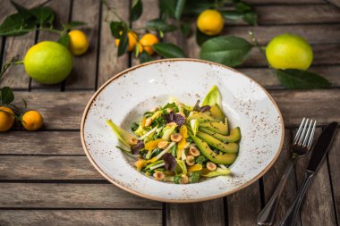 Taze salata avokado ve plaka üzerinde ahşap masa içinde fındık