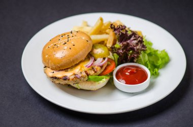 Burger ile Fransız kızartma ve beyaz tabakta ketçap