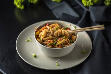 Siyah kumaş üzerine yemek çubukları ile plaka üzerinde Asya kase erişte