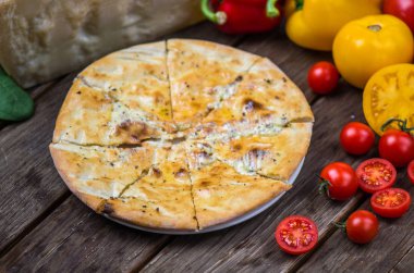 Ahşap masa üzerinde plaka üzerinde İtalyan pizza peyniri ve krema sos ile servis