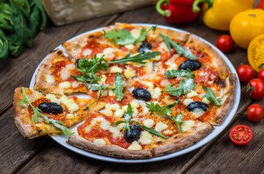 Roka ve ahşap masa tabakta servis zeytin İtalyan pizza