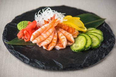 Beyaz arka planda arduvaz üzerinde taze Japon deniz ürünleri sashimi