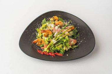 Beyaz arka planda siyah plaka servis deniz ürünleri salatası