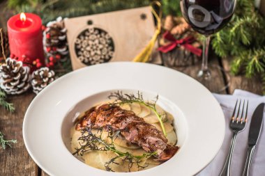 Kavrulmuş dilimlenmiş et ve patates ile Noel dekor ahşap masa üzerinde plaka üzerinde