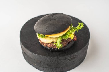 Parça ahşap beyaz arka plan üzerinde siyah sığır eti burger hizmet