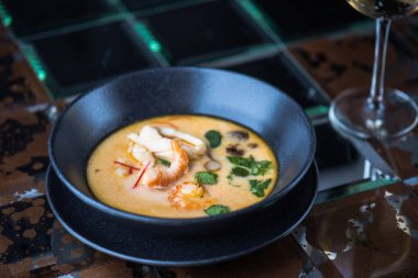 koyu arka plan üzerinde siyah kase hizmet deniz mahsulleri çorbası