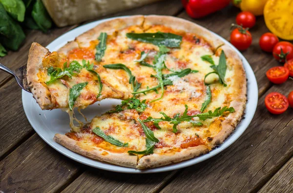Zbliżenie Gourmet Pizza Serem Parmezan Rukolą Pomidorami Drewnianym Stole — Zdjęcie stockowe