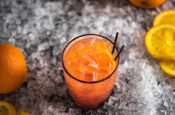 ガラス成分と氷の上でオレンジ色のカクテル — ストック写真