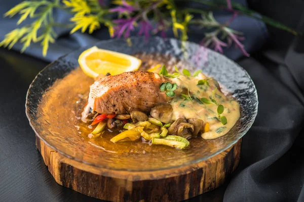在木板上的玻璃板上放上蔬菜和肉汁的三文鱼 — 图库照片
