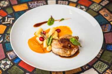 Renkli mozaik zemin üzerine beyaz tabakta ördek bacak garnitür ile servis