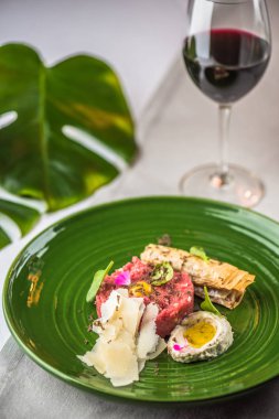 Yeşil plaka üzerinde peynir ve atıştırmalıklar ile servis biftek tartar