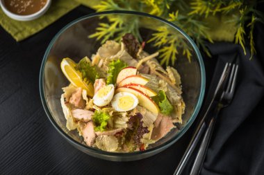 Tavuk, yumurta ve elma masa örtüsü üzerinde cam kase sebze meze salata