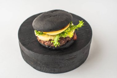Parça ahşap beyaz arka plan üzerinde siyah sığır eti burger hizmet