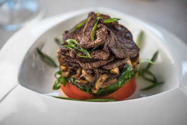 Beyaz tabakta et ve sebze yemek