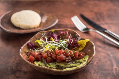 Yeşil ve kahverengi yüzeyi soslu plaka üzerinde otlar ile balık aperatif servis