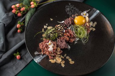 Siyah tabakta çiğ yumurta sarısı ile et tartar snack