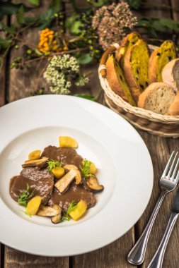 Mantar sos ve patates beyaz tabakta demlenmiş sığır eti