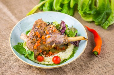 Masa örtüsü üzerinde kase garnitür ile kemik üzerinde et