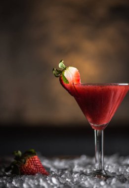 Martini cam Berry kokteyl buz ile koyu arka plan üzerinde çilek ile süslenmiş
