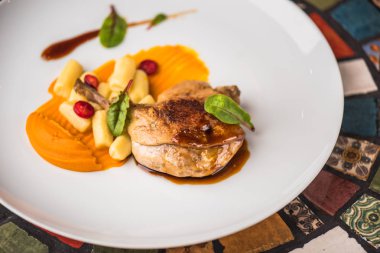 Renkli mozaik zemin üzerine beyaz tabakta ördek bacak garnitür ile servis