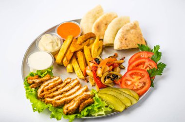 Beyaz arka plan üzerinde metal plaka üzerinde tabak yemek oryantal tarzı - kızarmış eti, ızgara biber, pide, domates, salatalık, patates, Humus, soslar