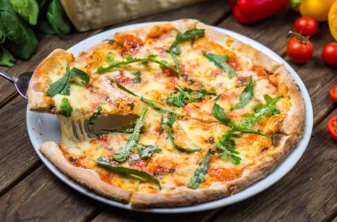 parmesan peyniri, roka ve domates ile güzel pişmiş pizza ahşap masa üzerinde görmek