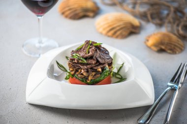 Beyaz tabakta et ve sebze yemek